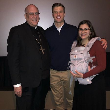 Isabelle Butker took a picture with her husband and child with Archbishop Numan.